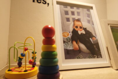 Montessori home setup with wooden stacking toy, bead maze and framed baby photo representing peaceful learning at Rumah Montessori Kecilku